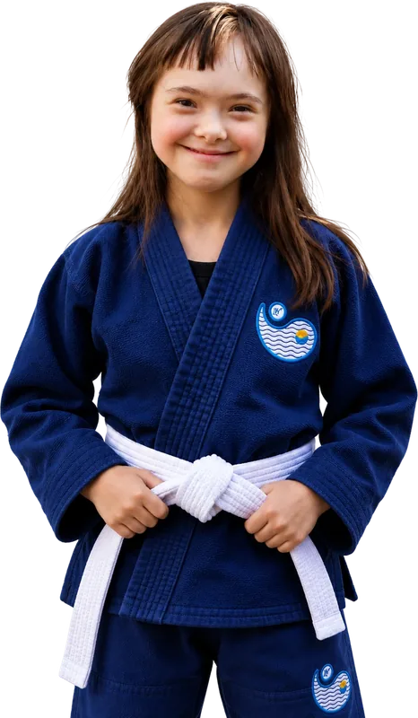A smiling young student in a navy gi and a white belt