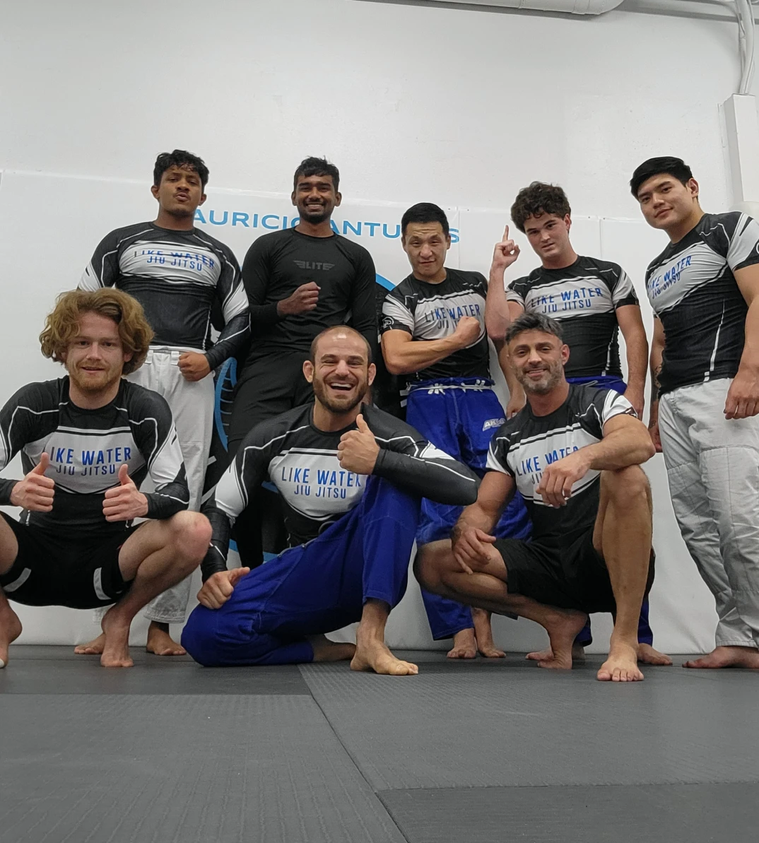 The no-gi group in Like Water rash guards posing together on the mat