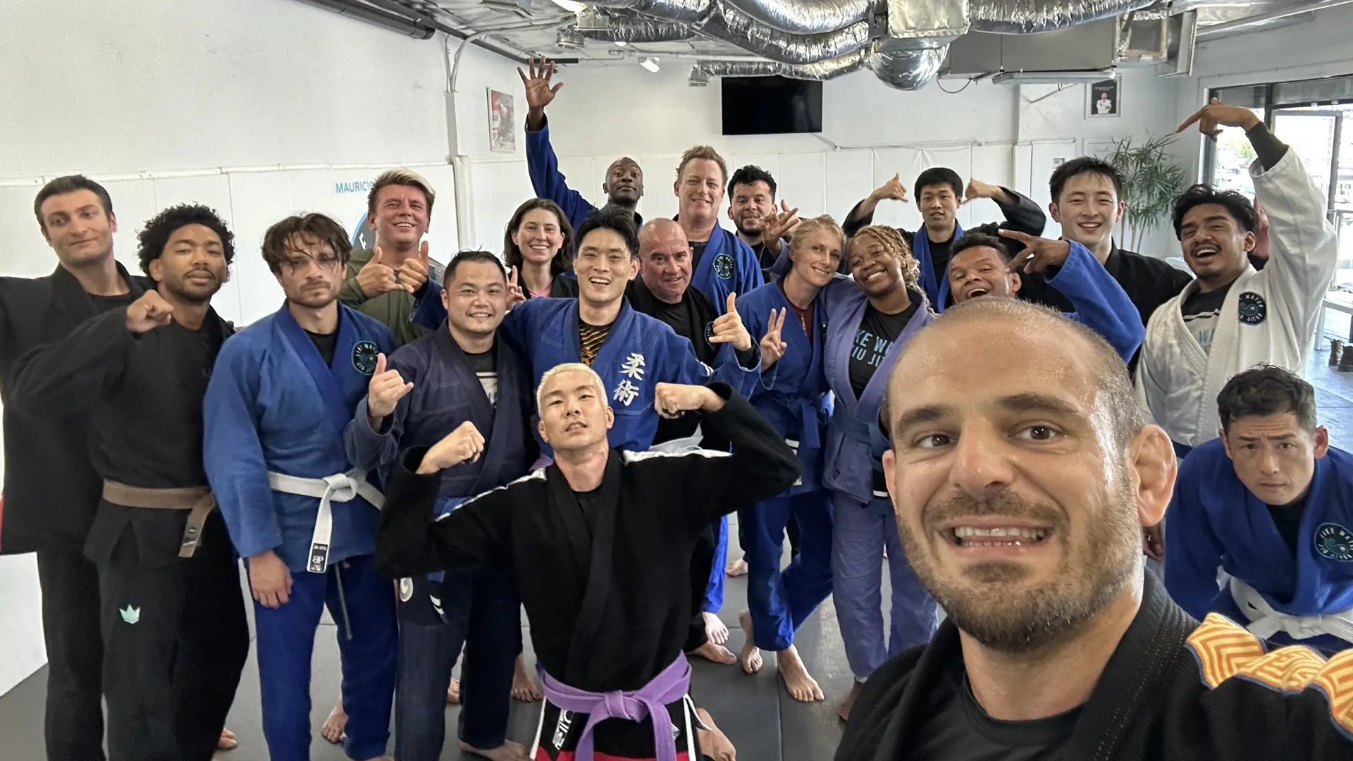 Mauricio taking a selfie with a big group of smiling students after class